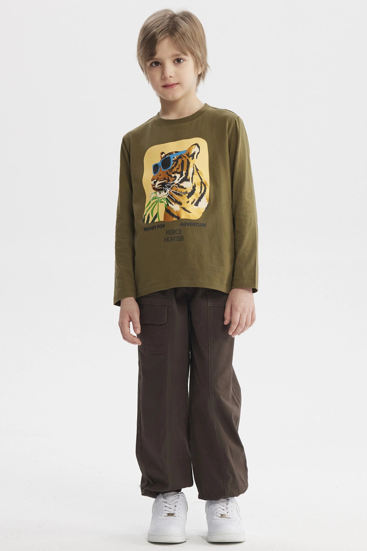 Polera de niño verde militar con estampado de tigre con gafas azules y texto Ready for Adventure Fierce Hunter en el pecho