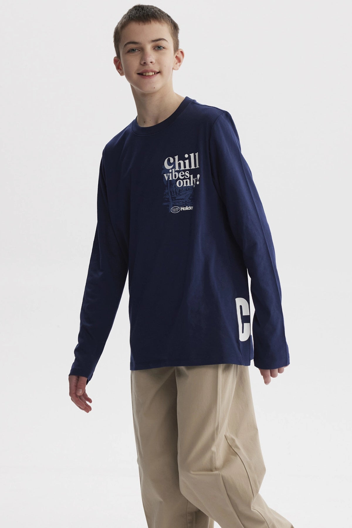 Polera azul oscuro para niño con texto Chill vibes only en el pecho diseño gráfico pequeño en estilo moderno