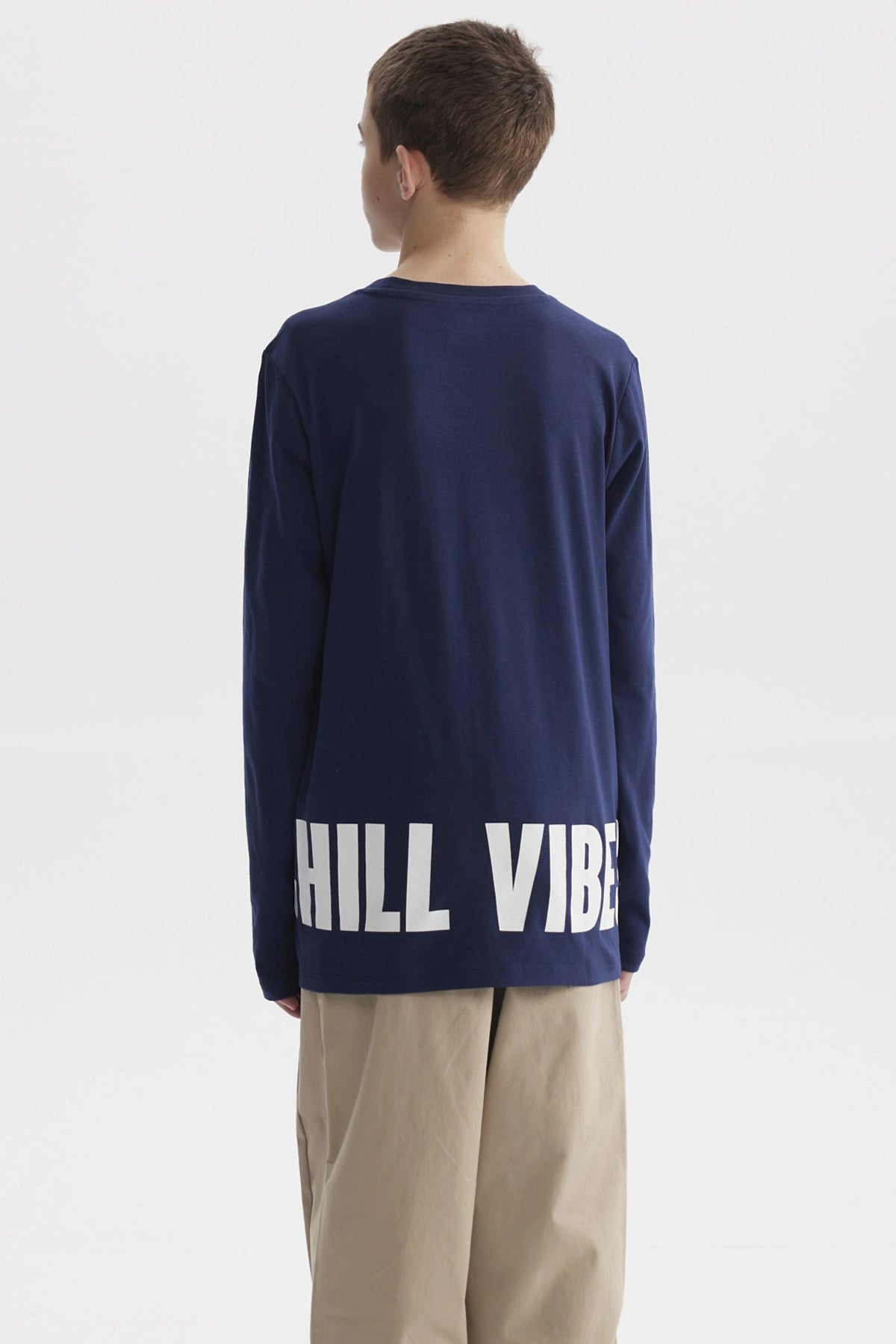 Polera azul oscuro para niño con texto Chill vibes only en el pecho diseño gráfico pequeño en estilo moderno