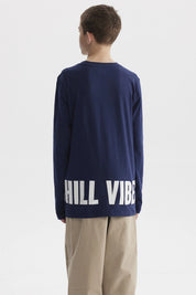 Polera azul oscuro para niño con texto Chill vibes only en el pecho diseño gráfico pequeño en estilo moderno