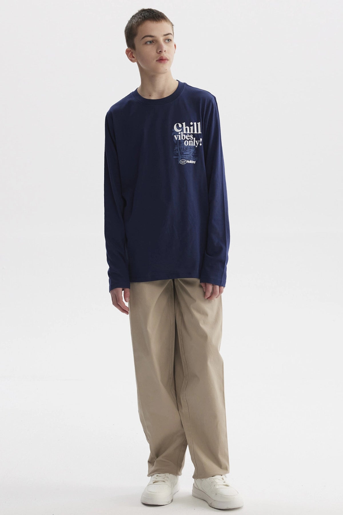 Polera azul oscuro para niño con texto Chill vibes only en el pecho diseño gráfico pequeño en estilo moderno