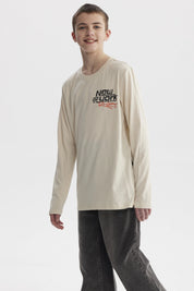 Polera de niño color crudo con estampado de texto 'New York' y bandera de cuadros en el pecho estilo urbano moderno