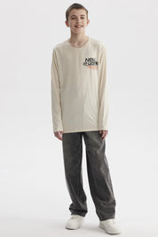 Polera de niño color crudo con estampado de texto 'New York' y bandera de cuadros en el pecho estilo urbano moderno