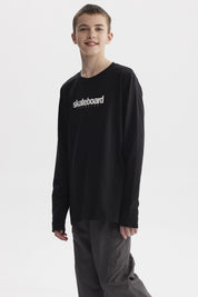 Polera negra de niño con texto blanco skateboard exercise en el pecho estilo casual urbano y manga larga lisa