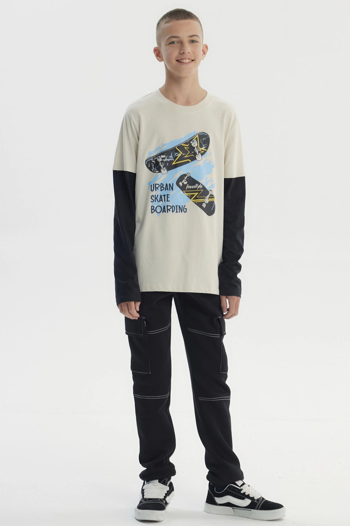 Polera de niño crudo con mangas negras y estampado central de skate estilo urbano