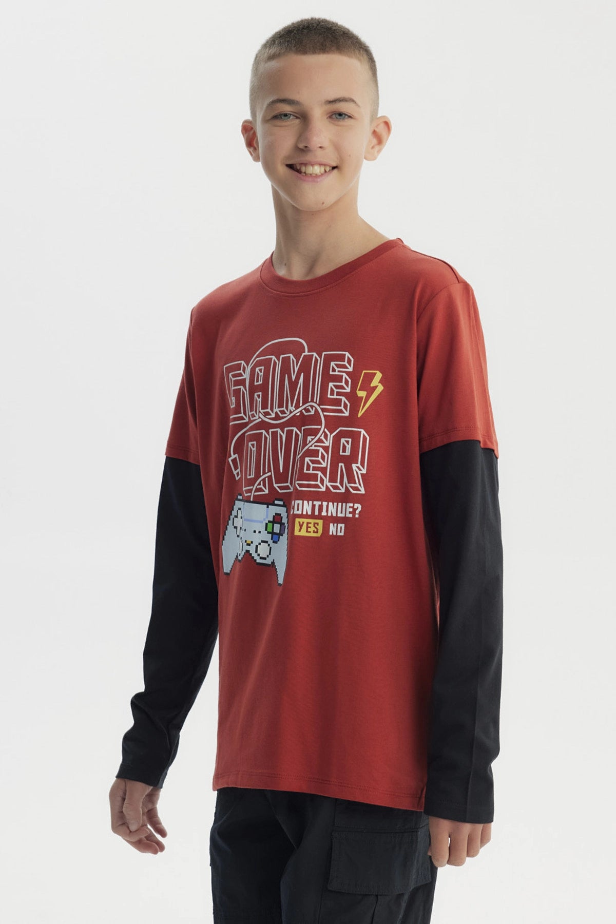 Polera niño ocre con estampado Game Over en el centro con mando de videojuegos en estilo pixelado