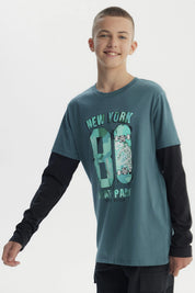 Polera niño verde oscuro con estampado central de texto New York 80 Skate Park y patinetas en estilo urbano graffiti