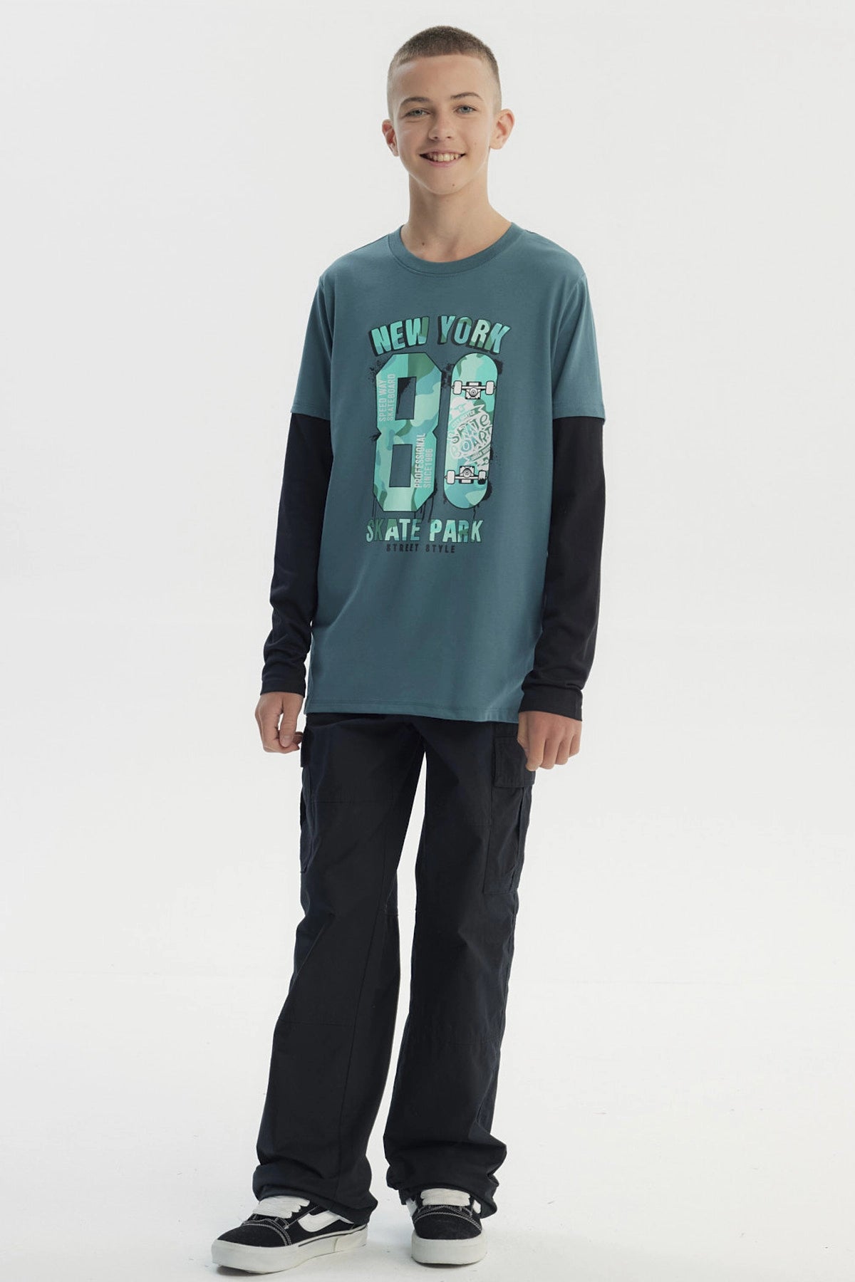 Polera niño verde oscuro con estampado central de texto New York 80 Skate Park y patinetas en estilo urbano graffiti