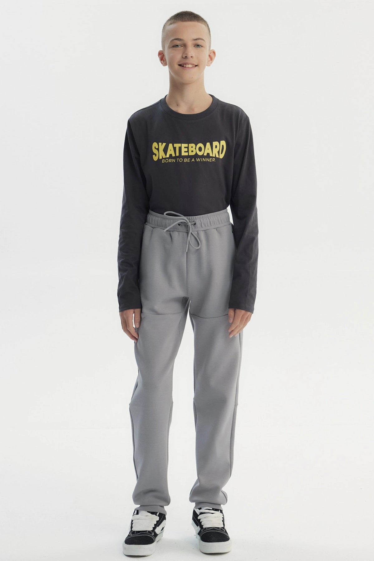 Pantalón buzo pitillo gris liso con cintura elástica y cordón frontal para niño