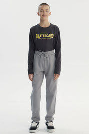 Pantalón buzo pitillo gris liso con cintura elástica y cordón frontal para niño