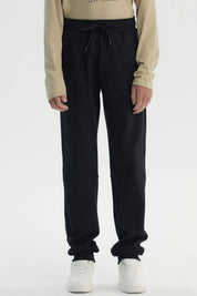 Pantalón buzo niño pitillo negro con ajuste elástico y cordón frontal prenda lisa cómoda para actividades diarias