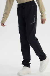 Pantalón buzo niño pitillo negro con ajuste elástico y cordón frontal prenda lisa cómoda para actividades diarias