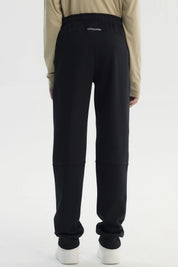 Pantalón buzo niño pitillo negro con ajuste elástico y cordón frontal prenda lisa cómoda para actividades diarias