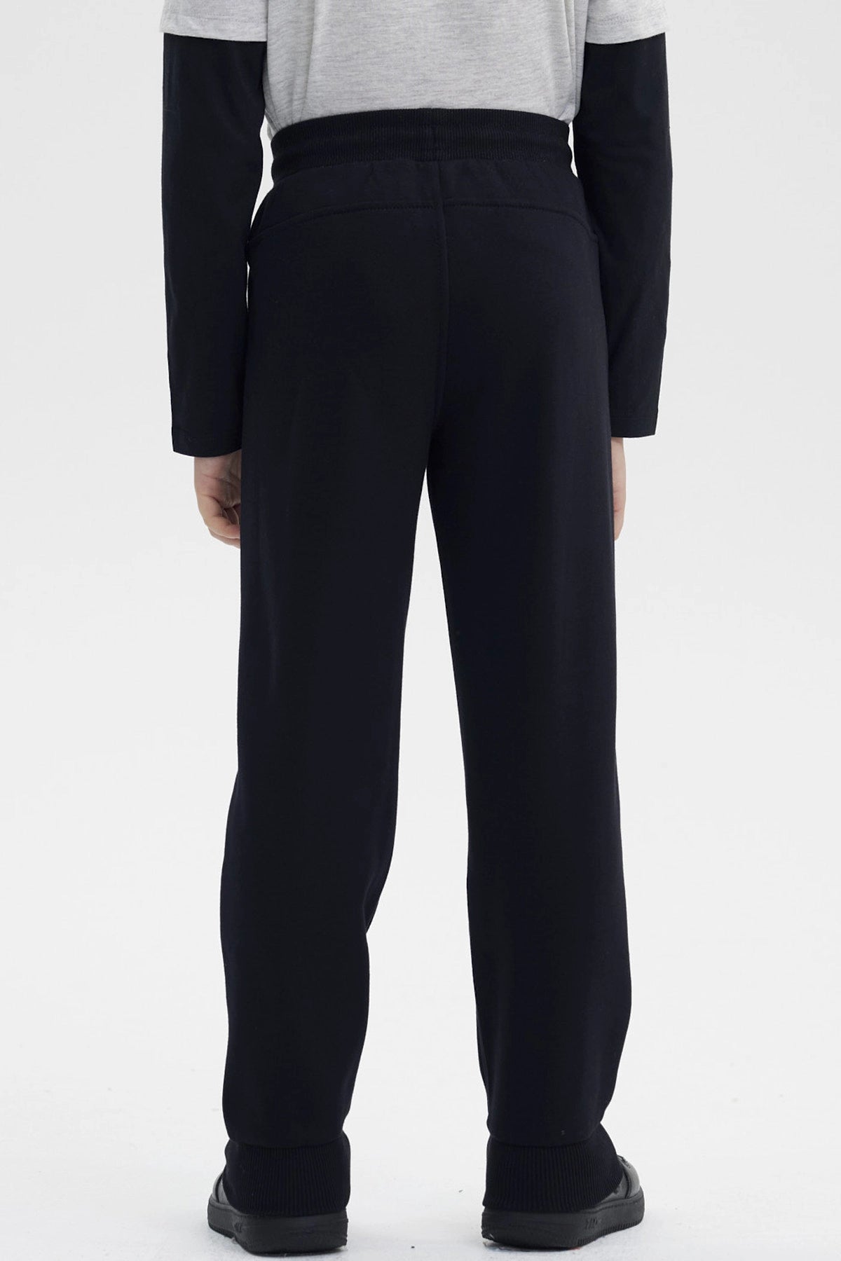 Pantalón buzo niño negro con ajuste en la cintura y texto Racing by Bike en la pierna derecha en estilo moderno