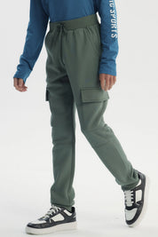 Pantalón buzo niño verde pitillo con bolsillos cargo en piernas diseño liso sin estampado ajuste con cordón