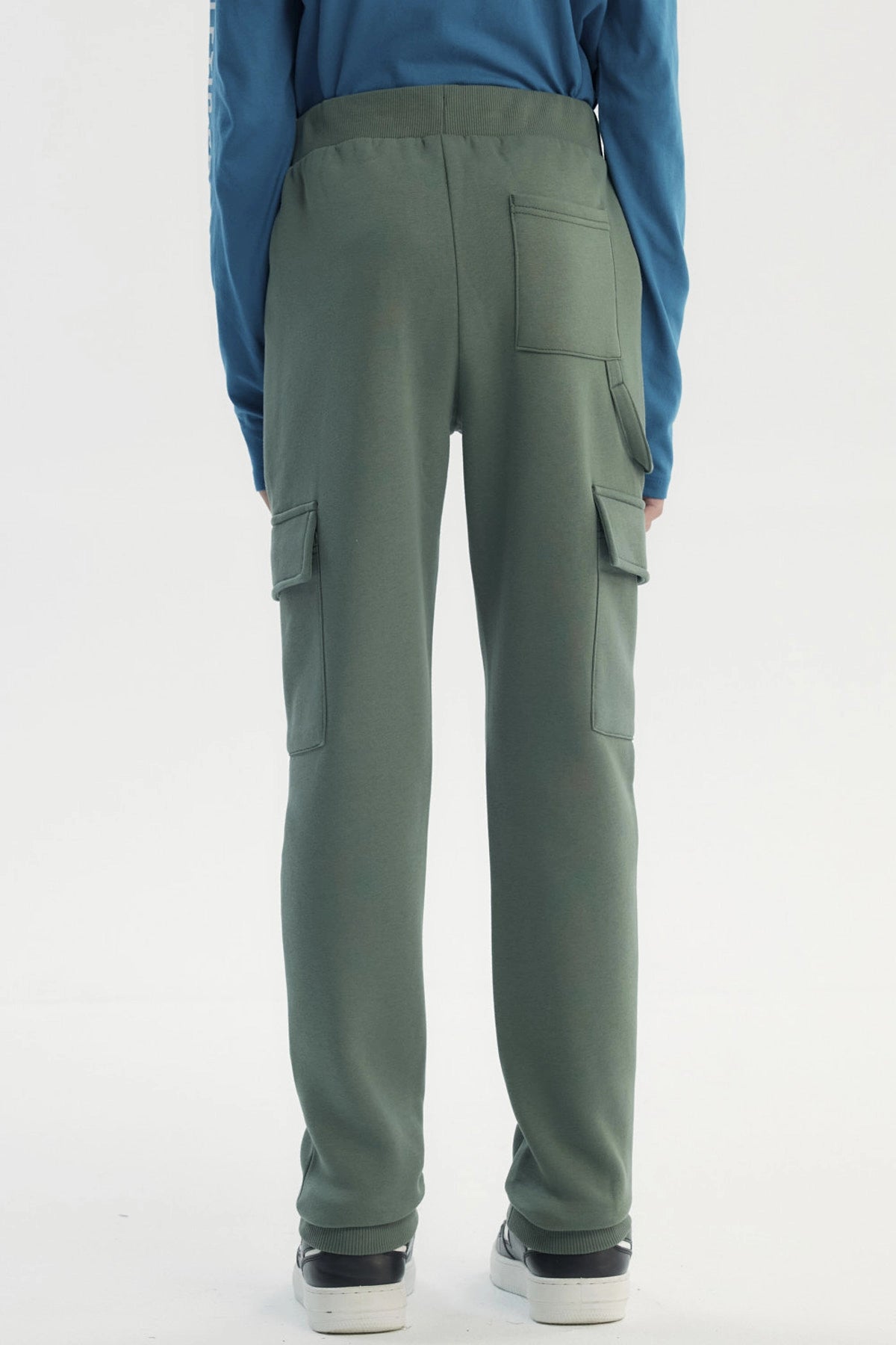 Pantalón buzo niño verde pitillo con bolsillos cargo en piernas diseño liso sin estampado ajuste con cordón