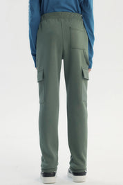 Pantalón buzo niño verde pitillo con bolsillos cargo en piernas diseño liso sin estampado ajuste con cordón
