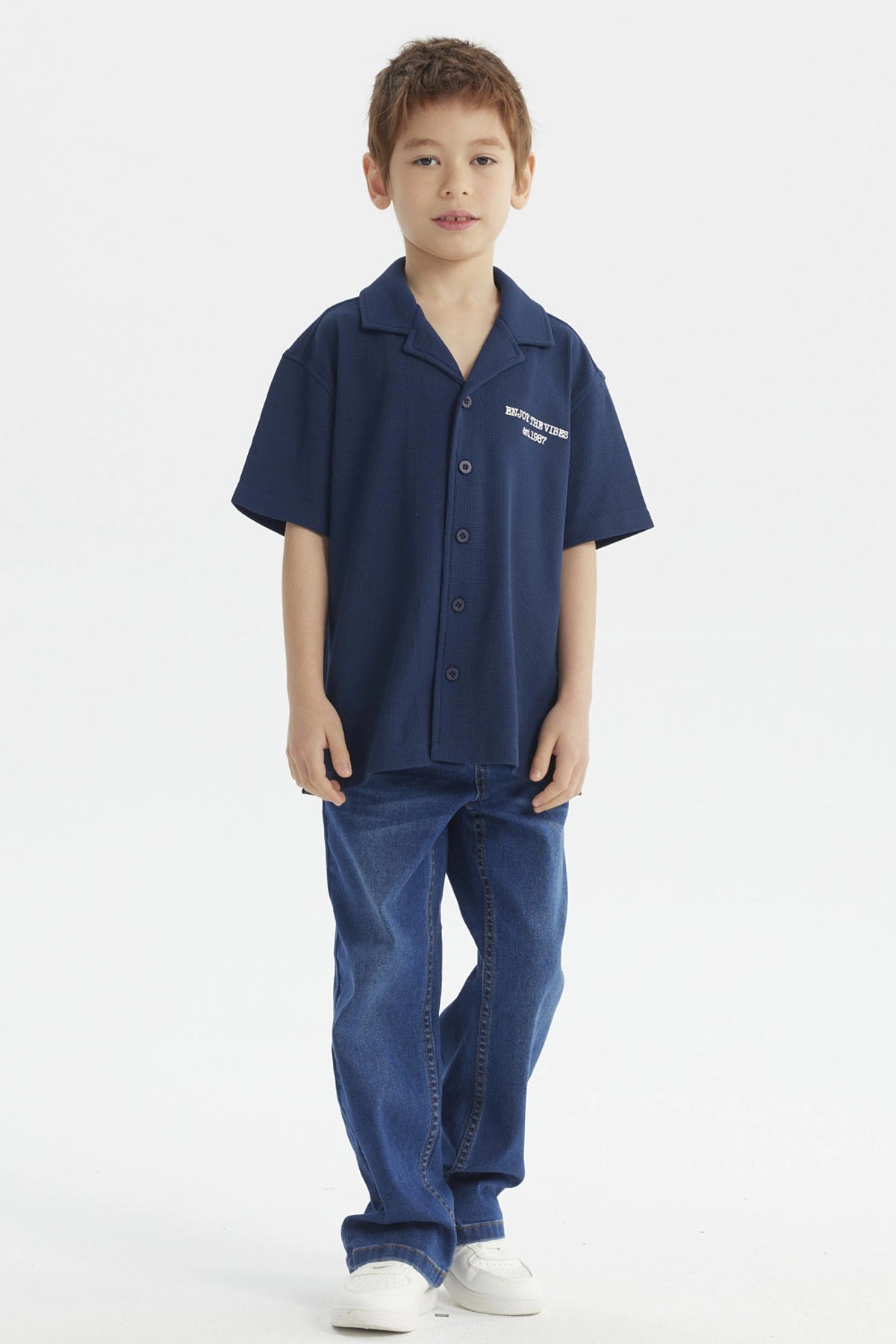 Camisa azul para niño con botones y texto blanco Enjoy the Vibes en el pecho diseño casual y moderno