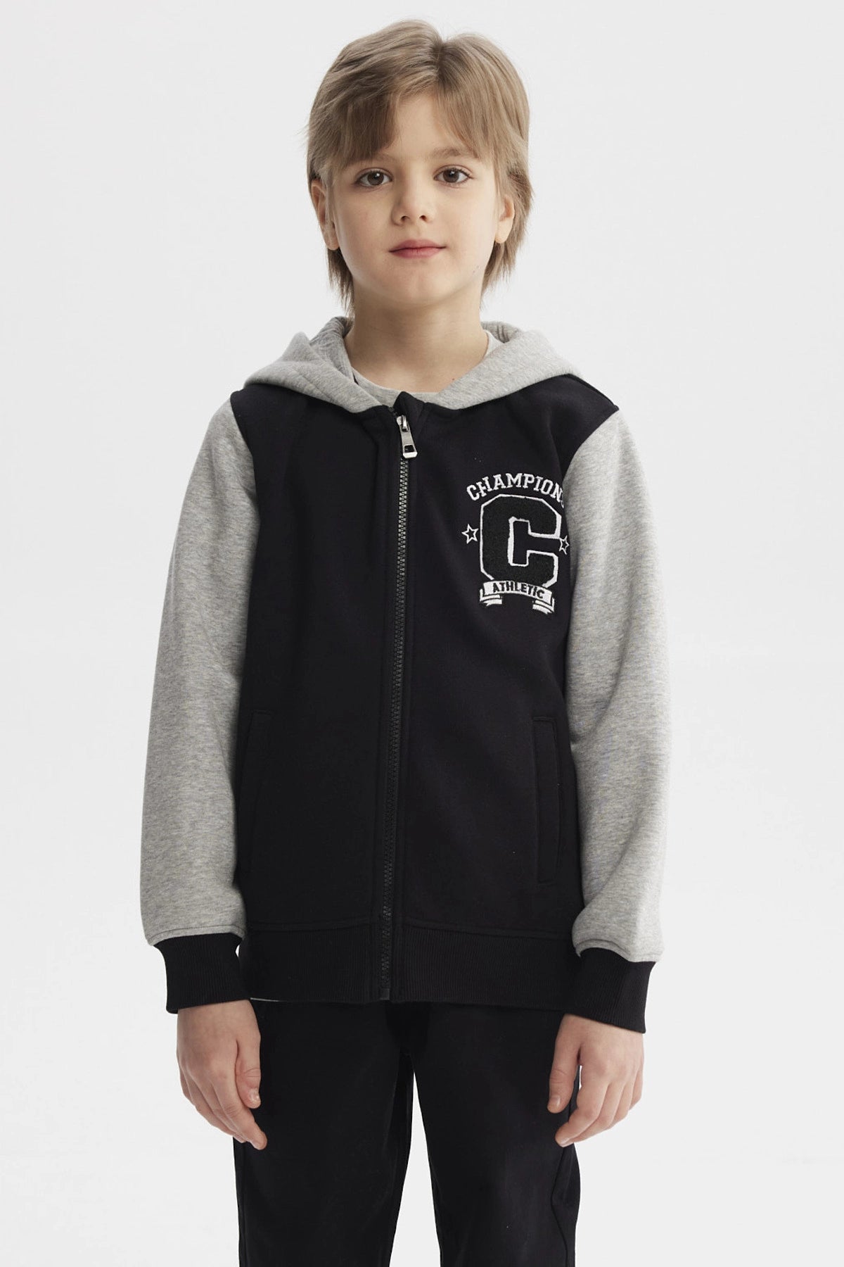 Chaqueta niño slim negro con mangas grises capucha y estampa de letras Champion C en el pecho