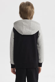 Chaqueta negra para niño con capucha y mangas grises diseño Champion C en el pecho estilo casual urbano