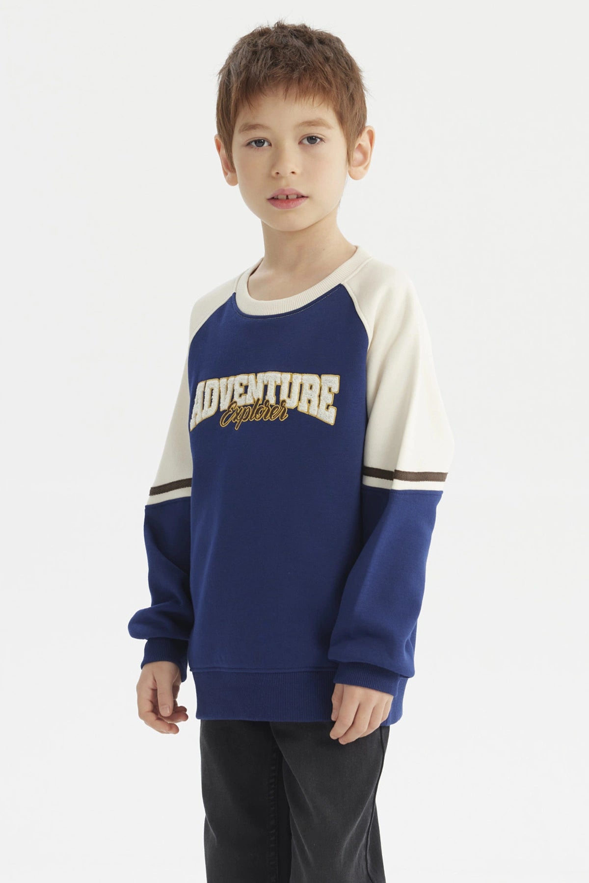 Polerón azul oscuro para niño con estampa Adventure Explorer en el pecho estilo casual con mangas crema y detalles marrones