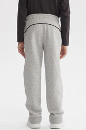 Pantalón buzo pitillo gris melange para niño con cintura ajustable y línea negra en el costado prenda lisa