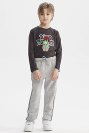 Pantalón buzo pitillo gris melange para niño con cintura ajustable y línea negra en el costado prenda lisa