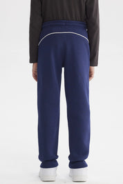 Pantalón buzo niño azul oscuro con líneas blancas laterales y texto Los Angeles en la cadera sin estampa visible