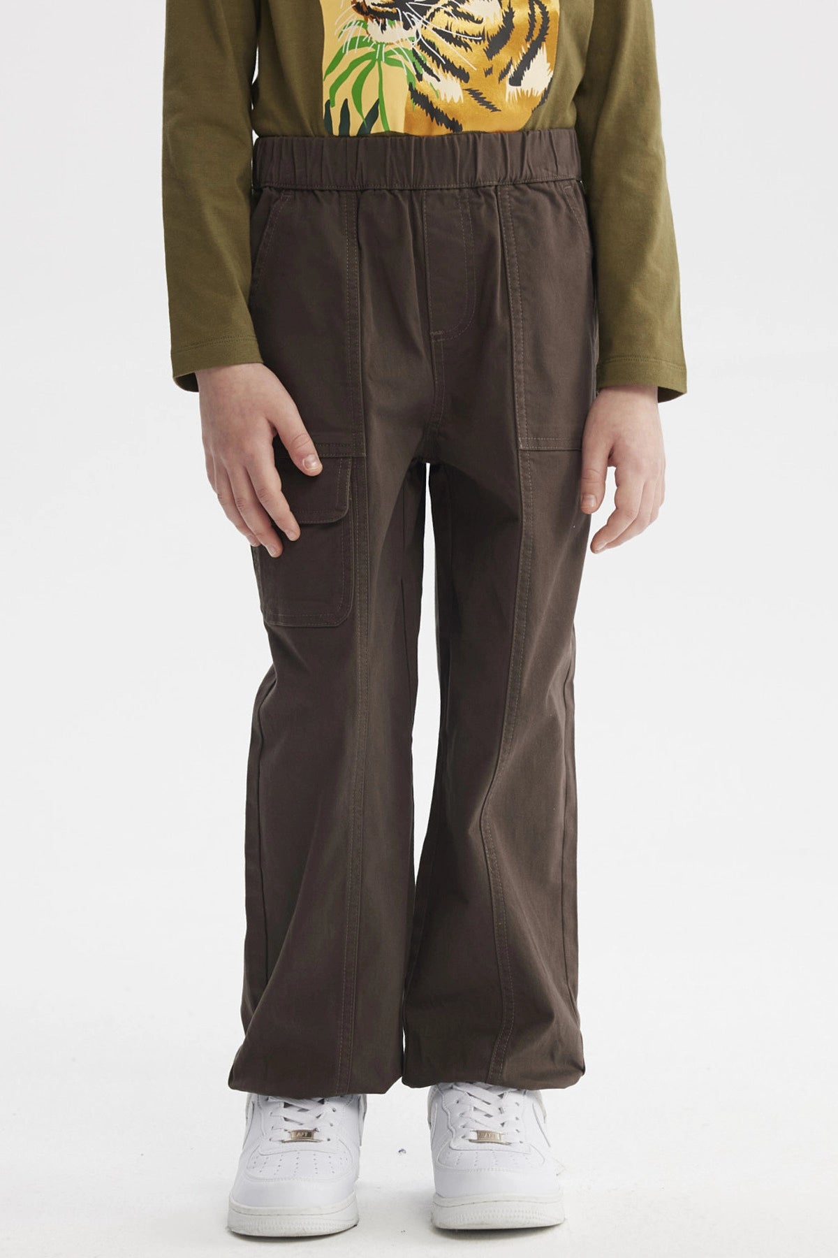 Pantalón niño pitillo café con bolsillos laterales ideal para un look casual sin estampa visible