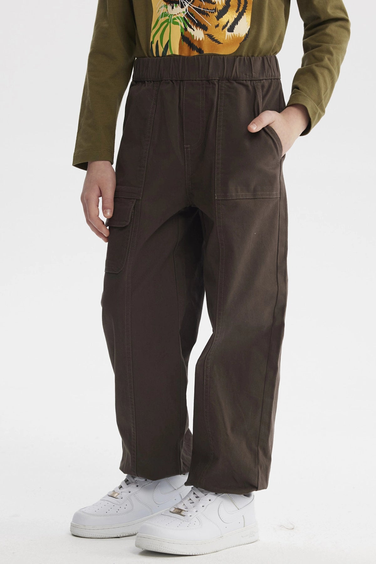 Pantalón niño pitillo café con bolsillos laterales ideal para un look casual sin estampa visible