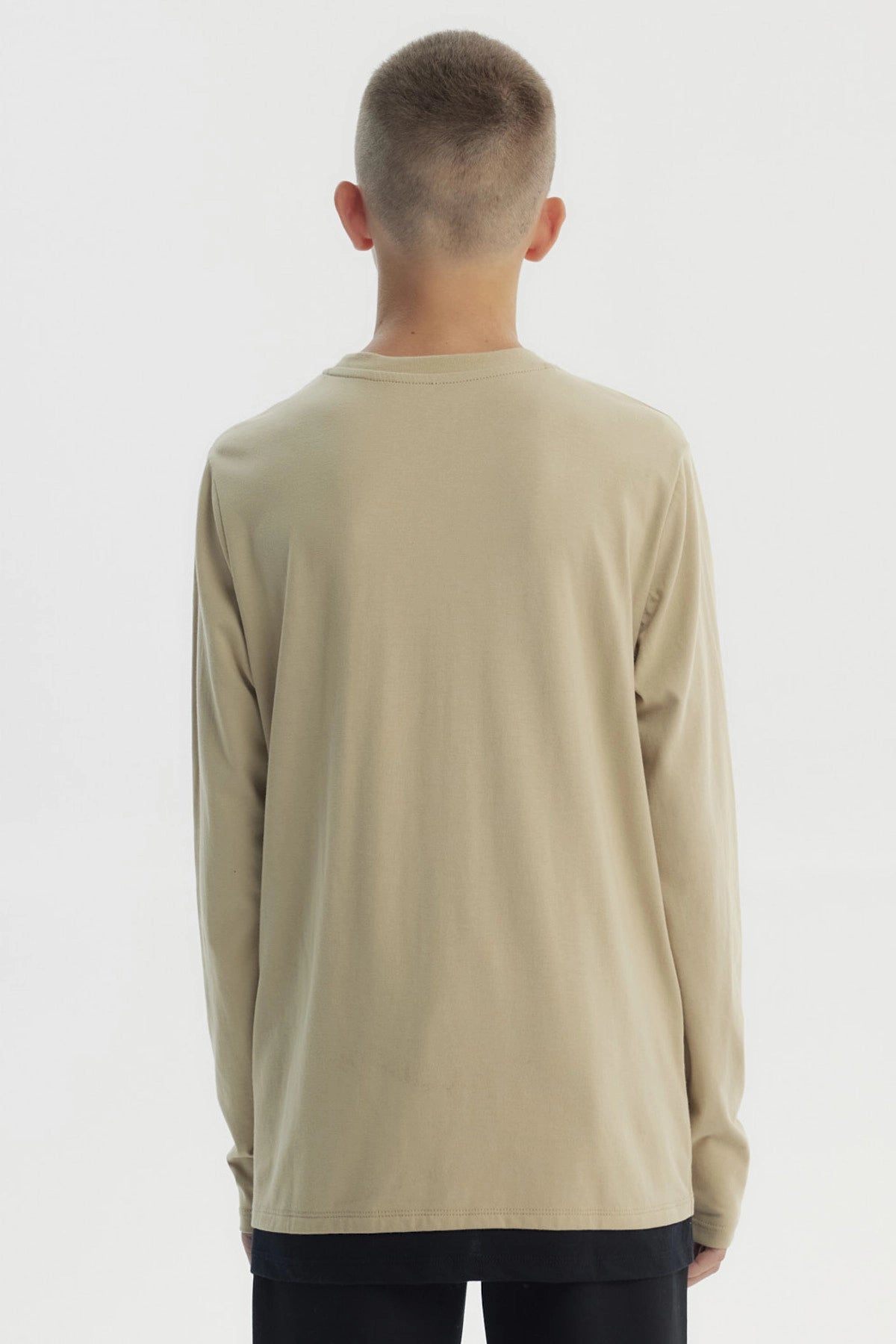 Polera slim kaki para niño con diseño frontal de texto Strong y paisaje montañoso estilo gráfico centrado