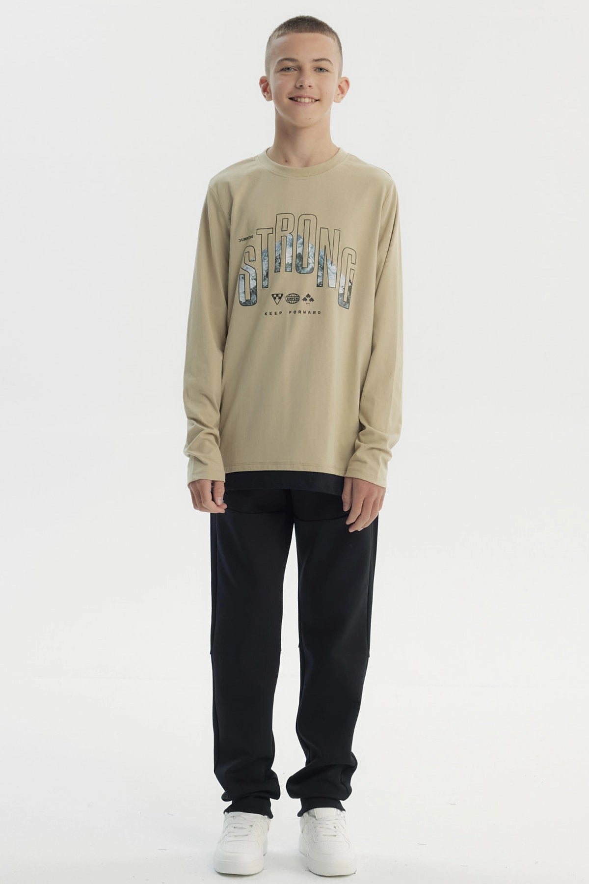 Polera slim kaki para niño con diseño frontal de texto Strong y paisaje montañoso estilo gráfico centrado