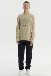 Polera slim kaki para niño con diseño frontal de texto Strong y paisaje montañoso estilo gráfico centrado