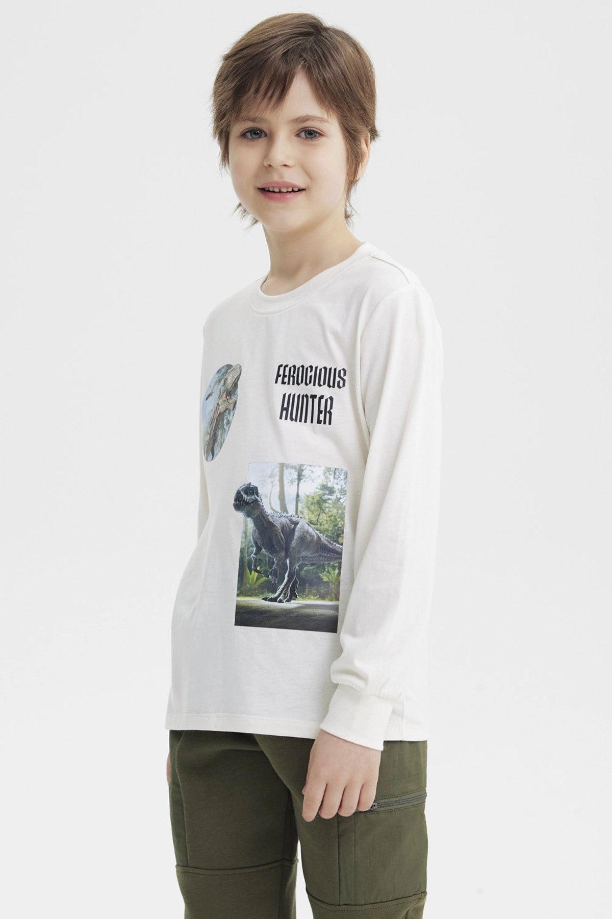 Polera niño crudo con estampado de dinosaurios y texto Ferocious Hunter en el pecho