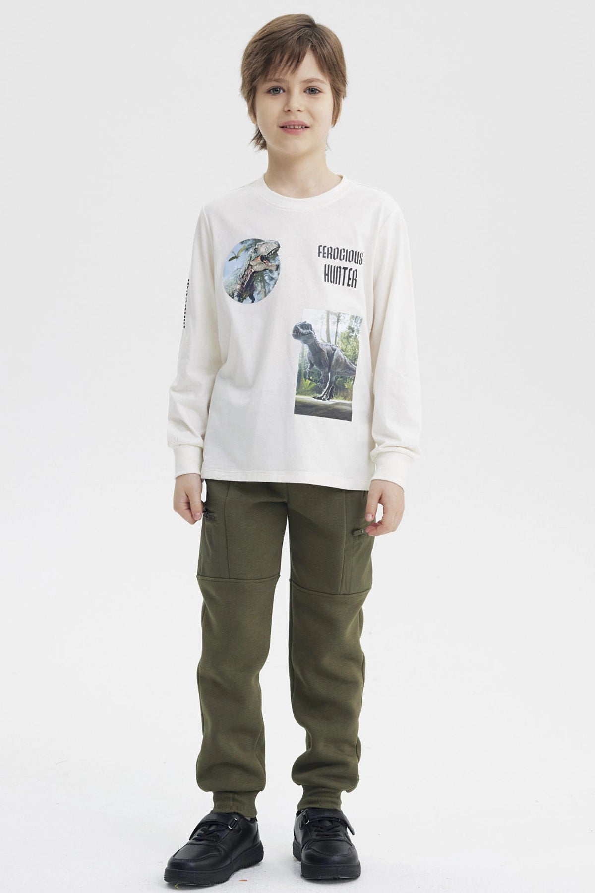 Polera niño crudo con estampado de dinosaurios y texto Ferocious Hunter en el pecho