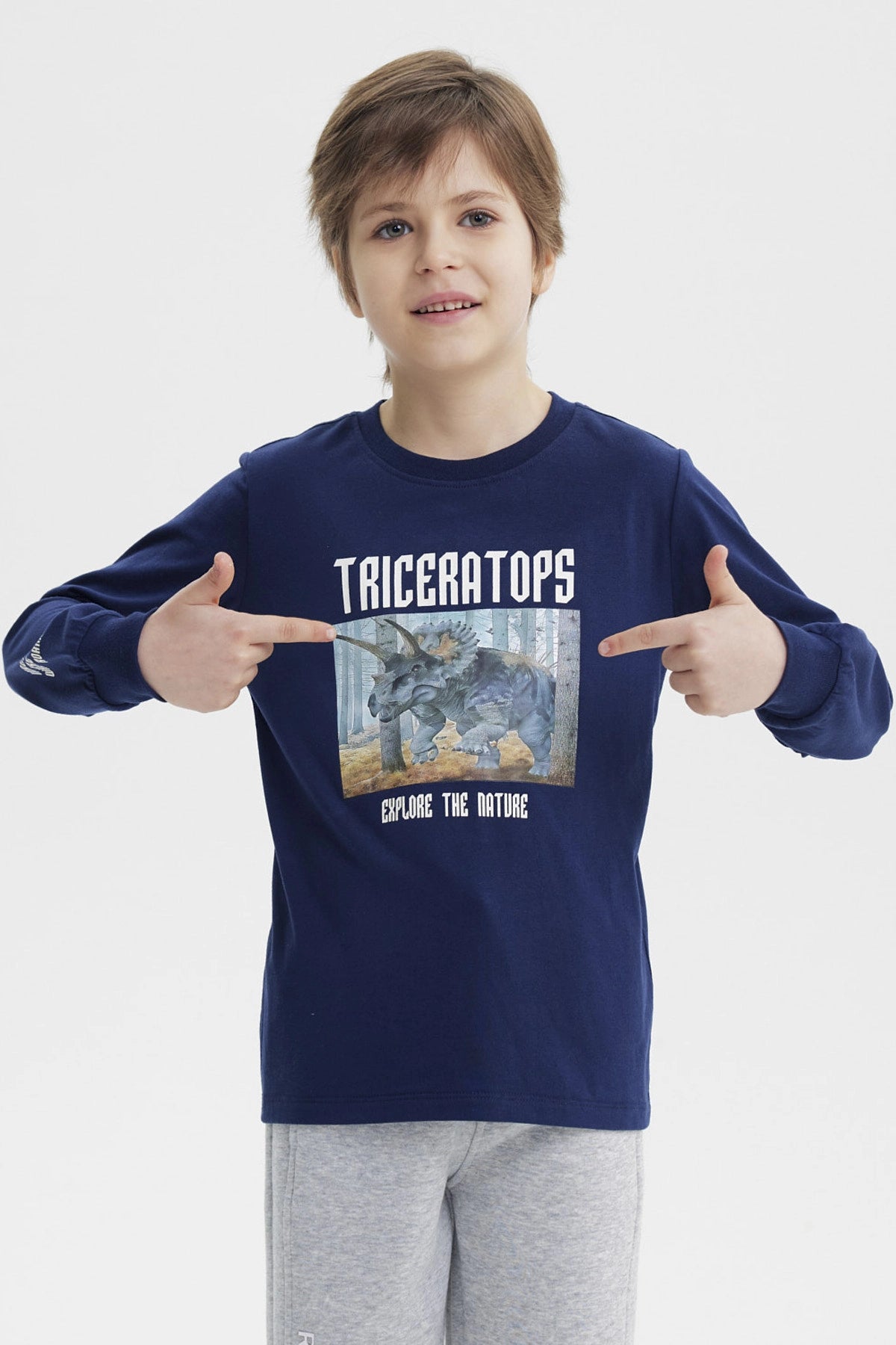 Polera azul oscuro para niño con estampa de triceratops en el bosque y texto Triceratops Explore the Nature en el frente