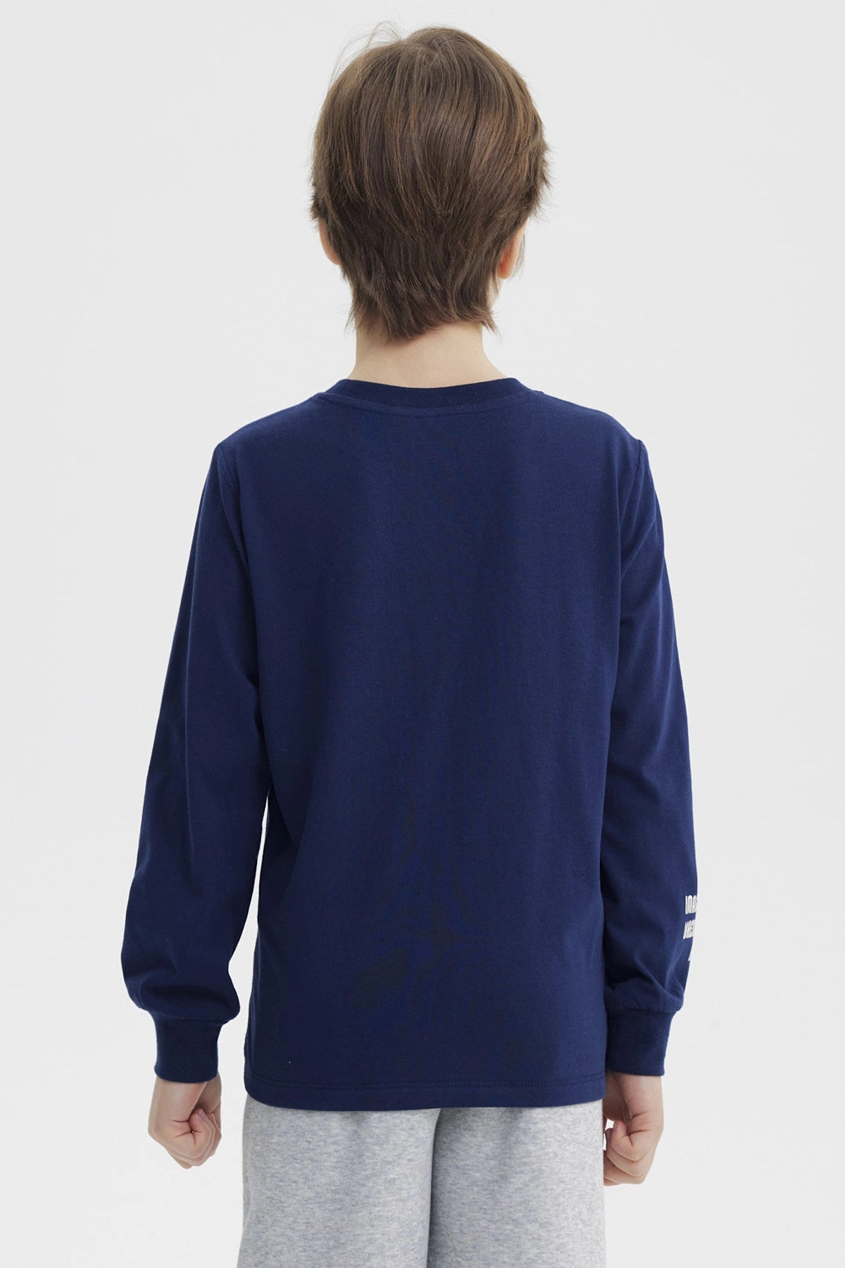 Polera azul oscuro para niño con estampa de triceratops en el bosque y texto Triceratops Explore the Nature en el frente