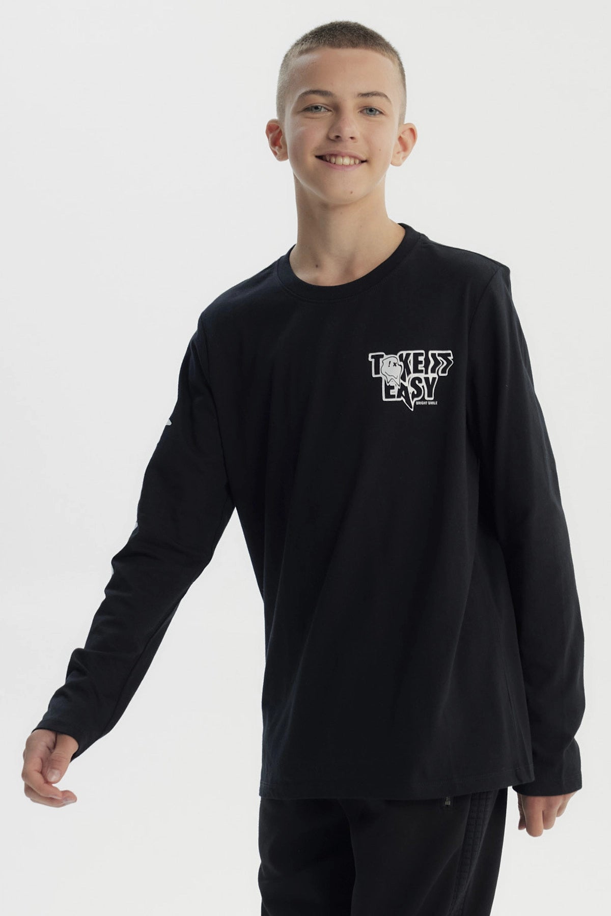 Polera negra de niño con diseño "Take it Easy" en el pecho y texto en la manga izquierda estilo urbano
