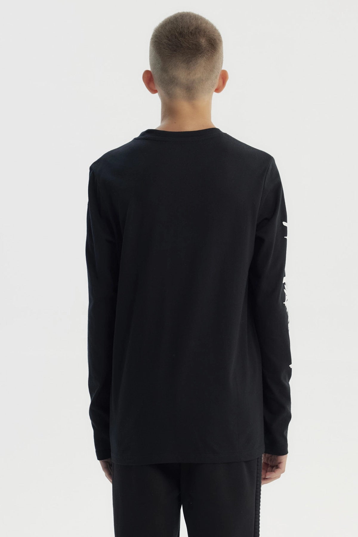 Polera negra de niño con diseño "Take it Easy" en el pecho y texto en la manga izquierda estilo urbano