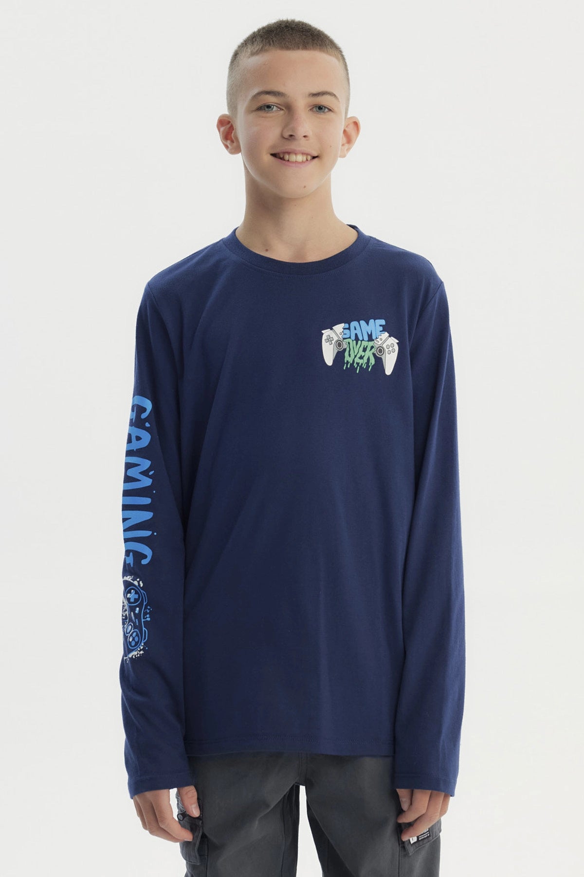 Polera niño azul oscuro con diseño de mandos y texto Game Over en el pecho y manga izquierda estampada con Gaming
