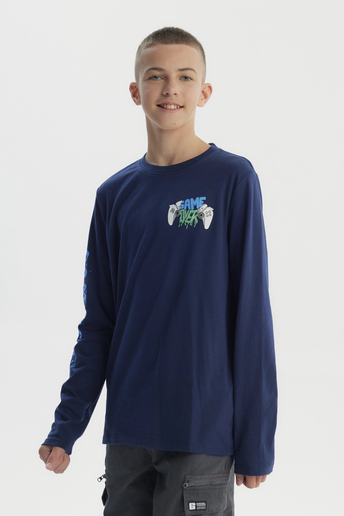 Polera niño azul oscuro con diseño de mandos y texto Game Over en el pecho y manga izquierda estampada con Gaming
