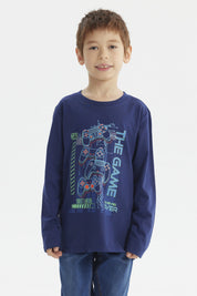 Polera de niño azul oscuro con estampado central de controles de videojuegos y texto The Game en estilo moderno