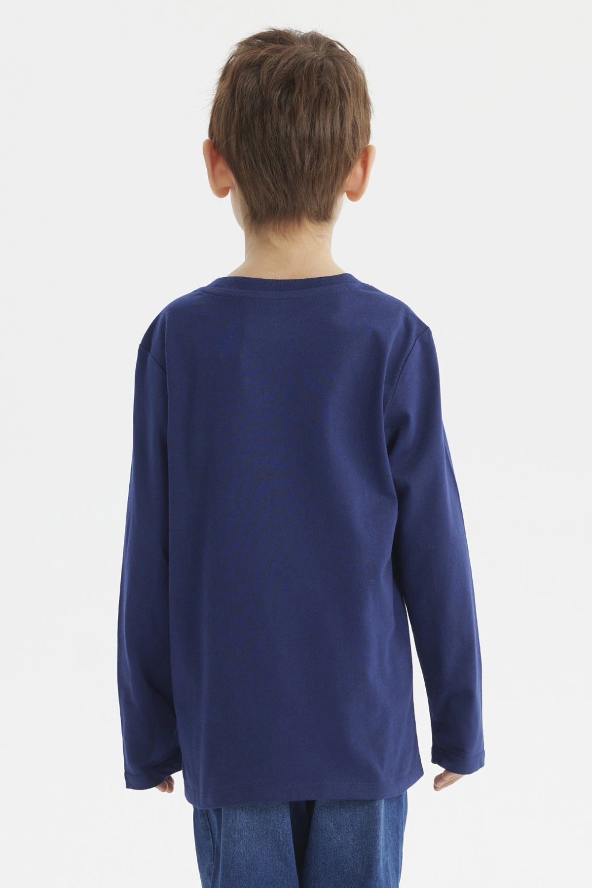 Polera de niño azul oscuro con estampado central de controles de videojuegos y texto The Game en estilo moderno