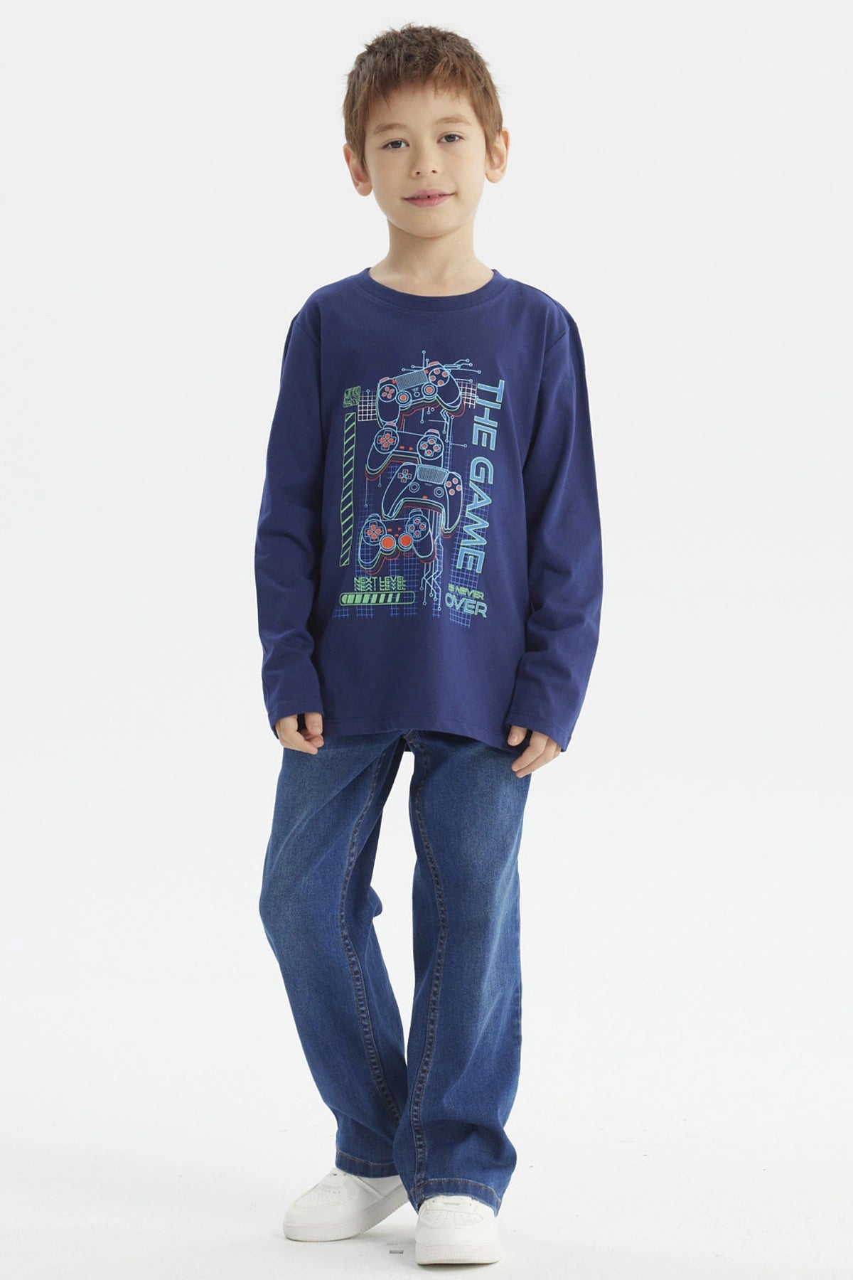Polera de niño azul oscuro con estampado central de controles de videojuegos y texto The Game en estilo moderno