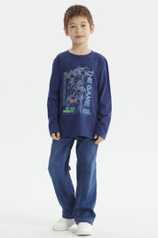 Polera de niño azul oscuro con estampado central de controles de videojuegos y texto The Game en estilo moderno