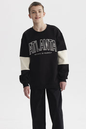 Polerón negro para niño con franjas blancas y texto ATLANTA en el pecho estilo casual gráfico moderno