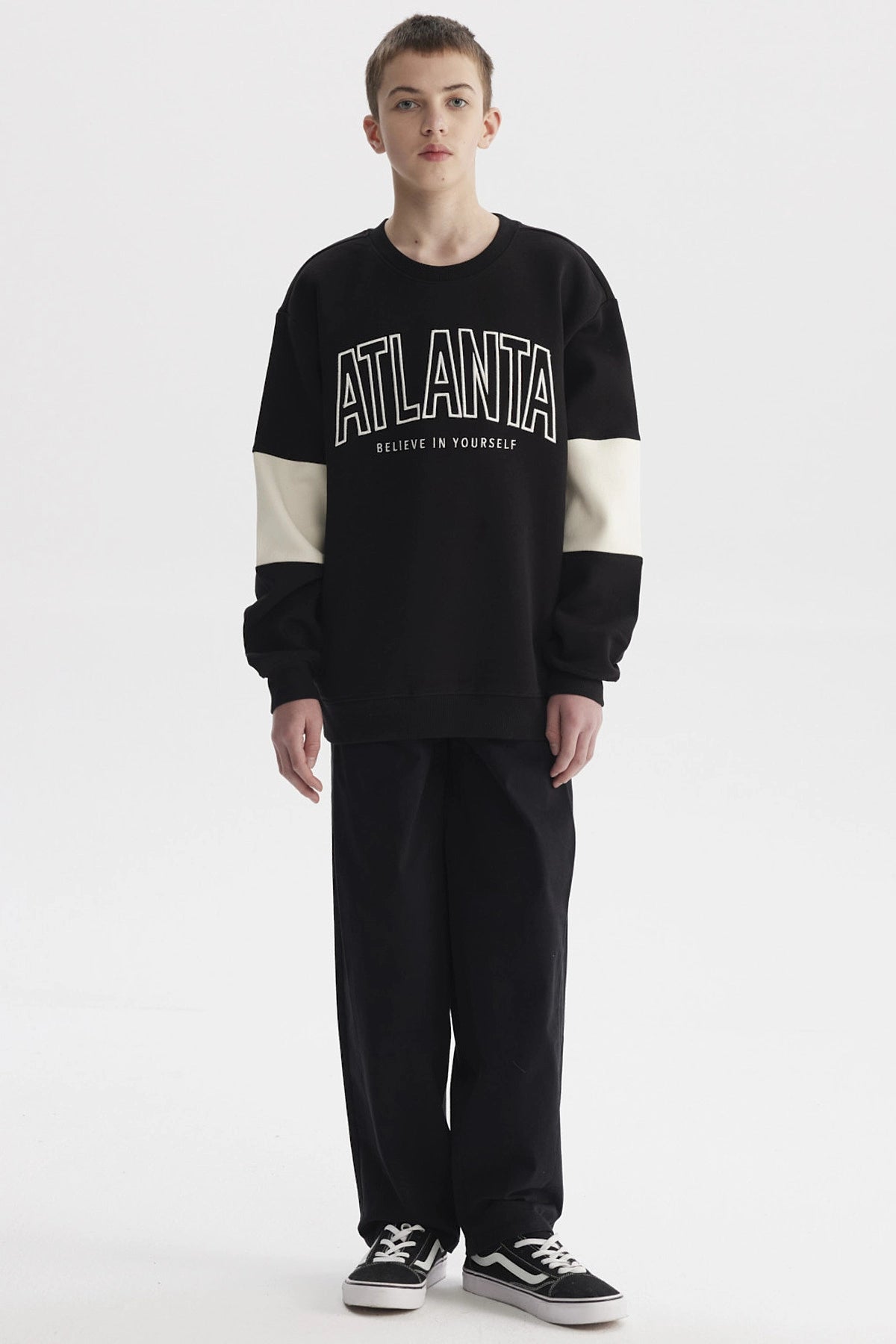Polerón negro para niño con franjas blancas y texto ATLANTA en el pecho estilo casual gráfico moderno