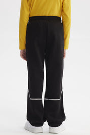 Pantalón buzo negro para niño con bolsillos y ajuste en cintura estampa blanca pequeña lateral "SUPER TEAM"
