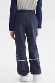 Pantalón buzo azul niño con ajuste en la cintura bolsillos delanteros y detalle de texto pequeño en el lateral izquierdo