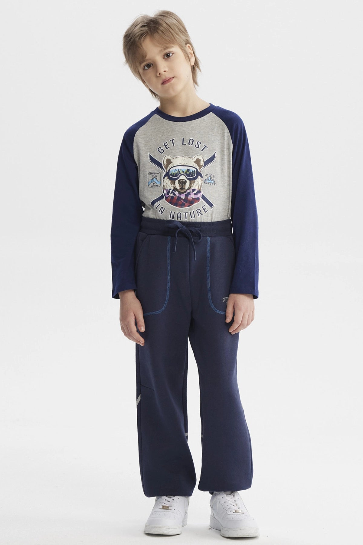 Pantalón buzo azul niño con ajuste en la cintura bolsillos delanteros y detalle de texto pequeño en el lateral izquierdo